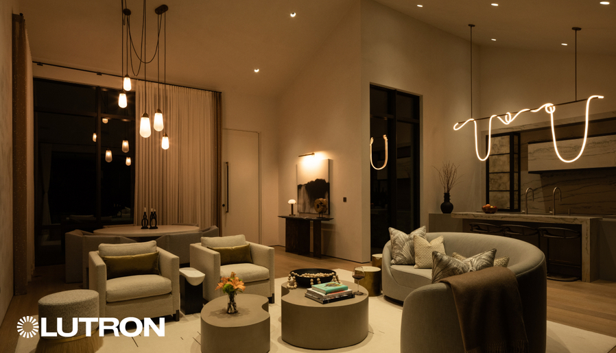 Modern living room with warm lighting, pendant fixtures, and contemporary seating, Lutron logo visible.